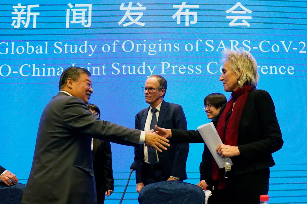 Liang Wannian (left) greets fellow members of a WHO Covid-19 mission, in Wuhan last year. Photo: AP