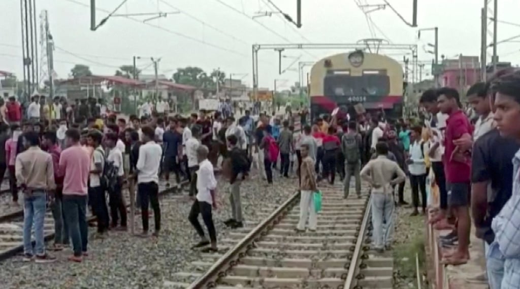 Demonstrators block a train as they protest against “Agnipath scheme” for recruiting personnel for armed forces, in Jehanabad, Bihar, India on Thursday. Photo: ANI/Handout via Reuters