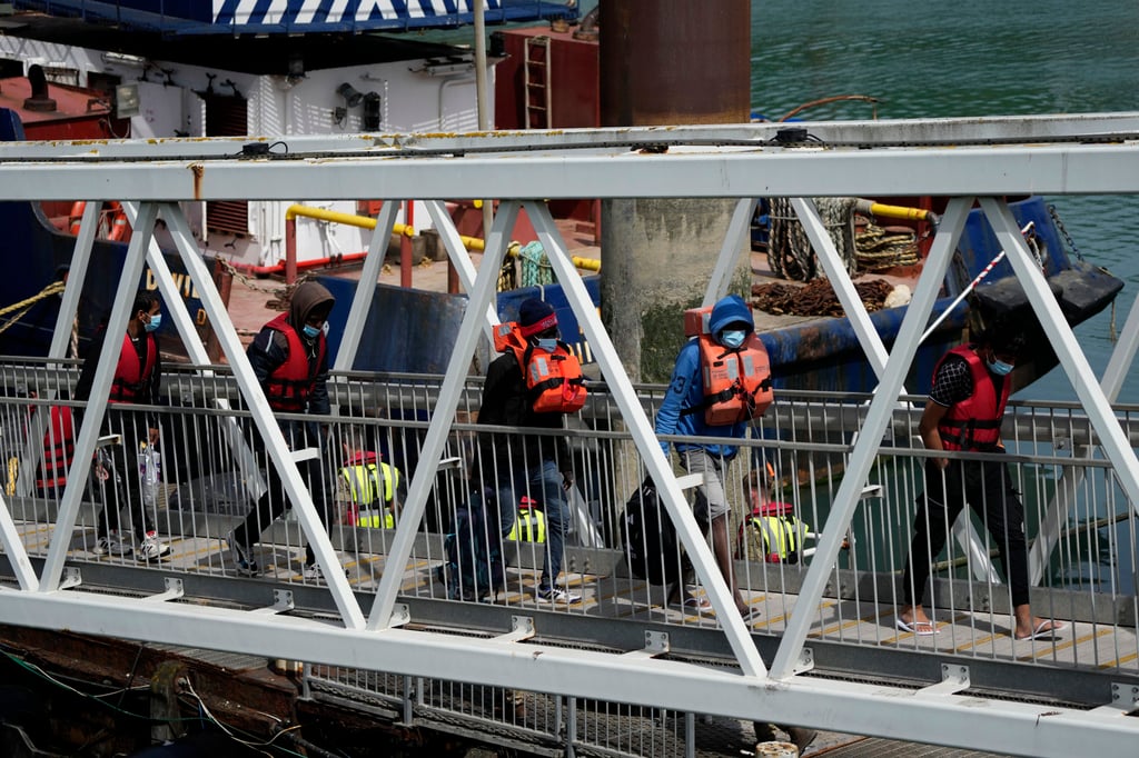 People thought to be migrants who undertook the crossing from France in small boats and were picked up in the Channel, arrive in southeast England on Friday. Photo: AP