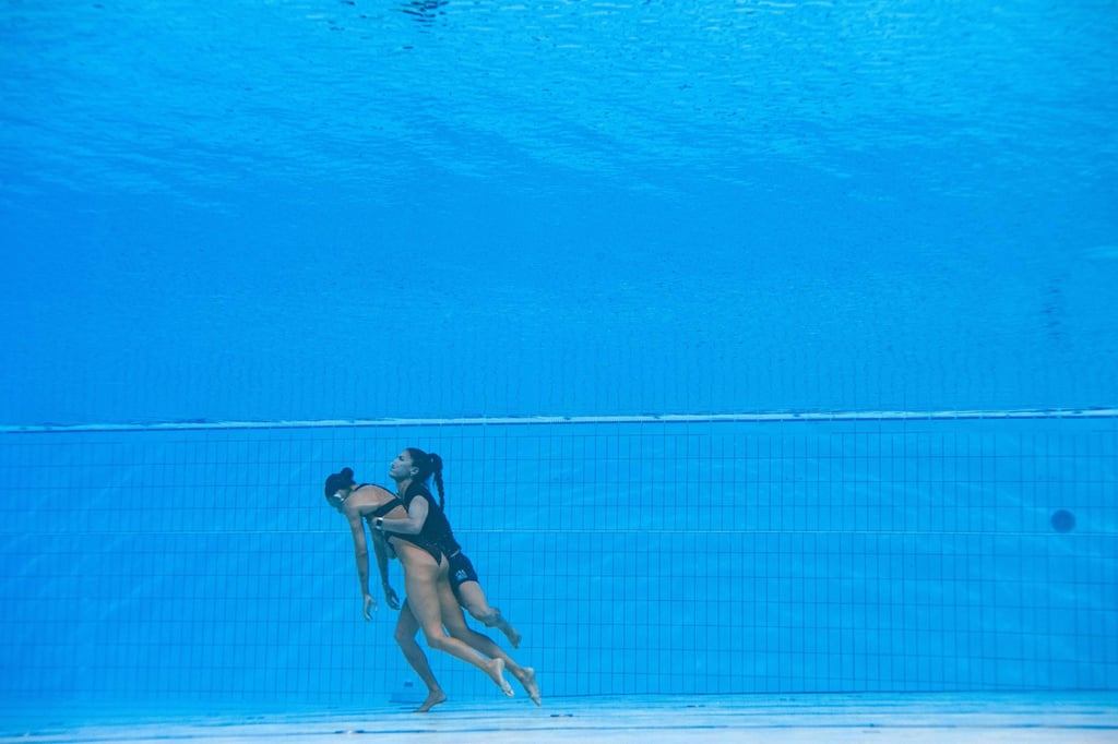Fuentes pushes off the bottom of the pool during the rescue. Photo: AFP