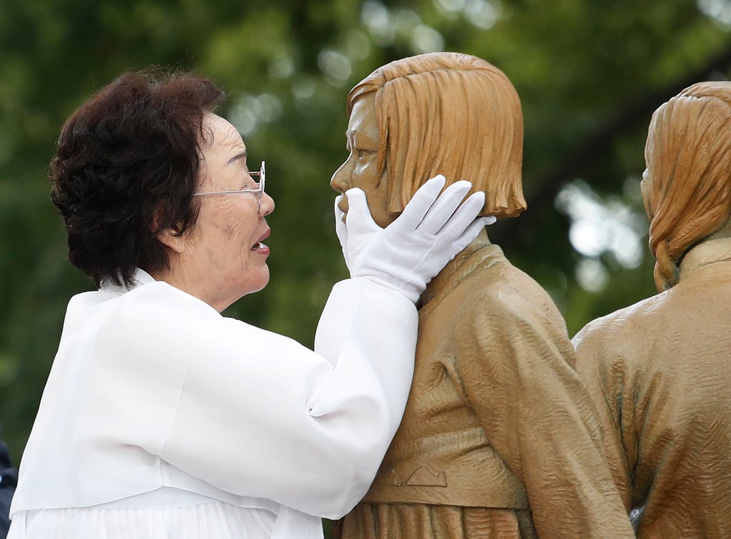 Lee Yong-soo, a South Korean survivor of sexual slavery, with the statue of a girl symbolising the issue of wartime “comfort women” during an unveiling ceremony in Seoul in 2019. Photo: AP Lee Yong-soo, a South Korean survivor of sexual slavery, with the statue of a girl symbolising the issue of wartime “comfort women” during an unveiling ceremony in Seoul in 2019. Photo: AP