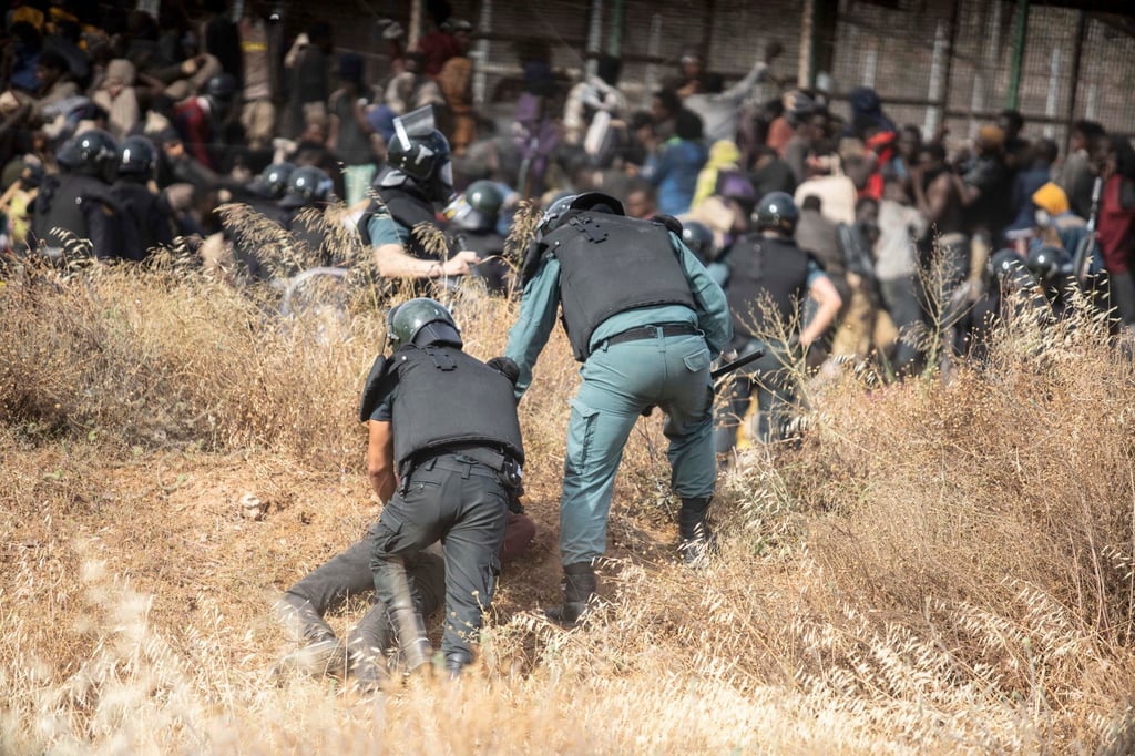 A migrant is detained by police officers in the Spanish enclave of Melilla on Friday. Photo: AP A migrant is detained by police officers in the Spanish enclave of Melilla on Friday. Photo: AP