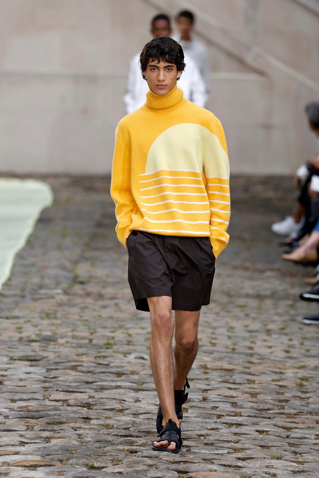 A model presents a yellow jumper with a sunset design, paired with black shorts and shoes, from Hermès’ spring/summer 2023 collection during men’s fashion week in Paris, France, on June 25. Photo: Xinhua A model presents a yellow jumper with a sunset design, paired with black shorts and shoes, from Hermès’ spring/summer 2023 collection during men’s fashion week in Paris, France, on June 25. Photo: Xinhua