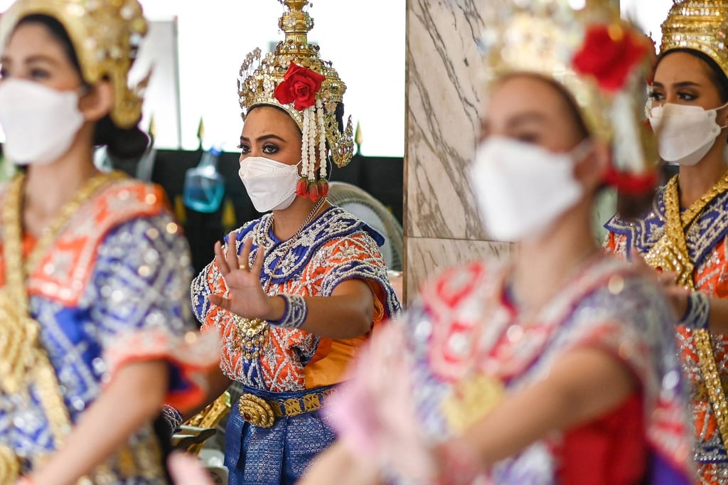 Traditional Thai dancers wearing face masks perform at a shrine in Bangkok earlier this month. Thailand dropped rules requiring people to wear masks on June 24. Photo: AFP