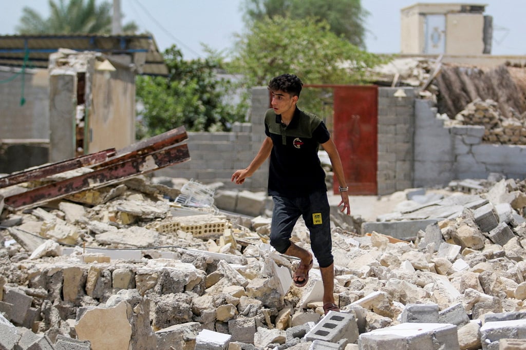 A man walks amid the rubble after a fatal earthquake in Iran on Saturday. Photo: via Reuters