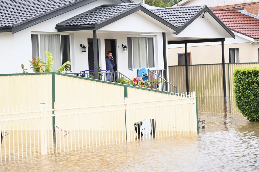 A resident looks out at floodwaters from his home in Chittaway Bay on the Central Coast, North of Sydney, New South Wales, Australia. Photo: EPA-EFE