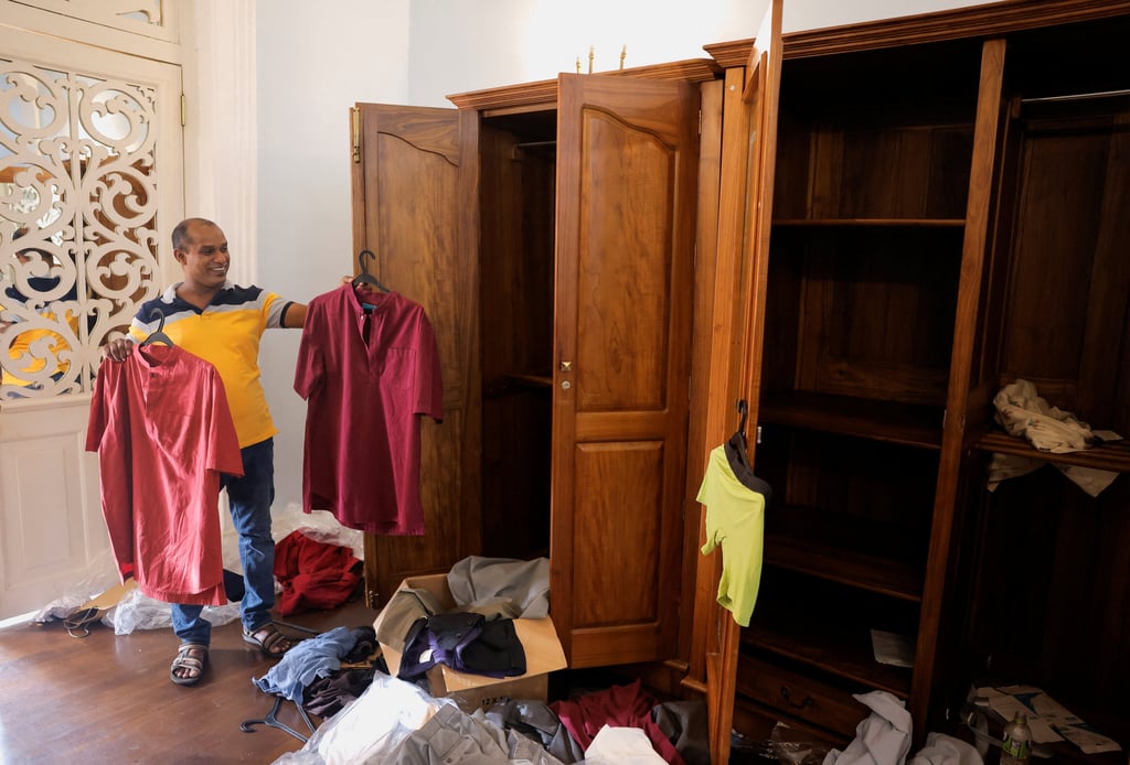 A man holds shirts belonging to President Gotabaya Rajapaksa inside the president’s house after demonstrators entered the building. Photo: Reuters A man holds shirts belonging to President Gotabaya Rajapaksa inside the president’s house after demonstrators entered the building. Photo: Reuters