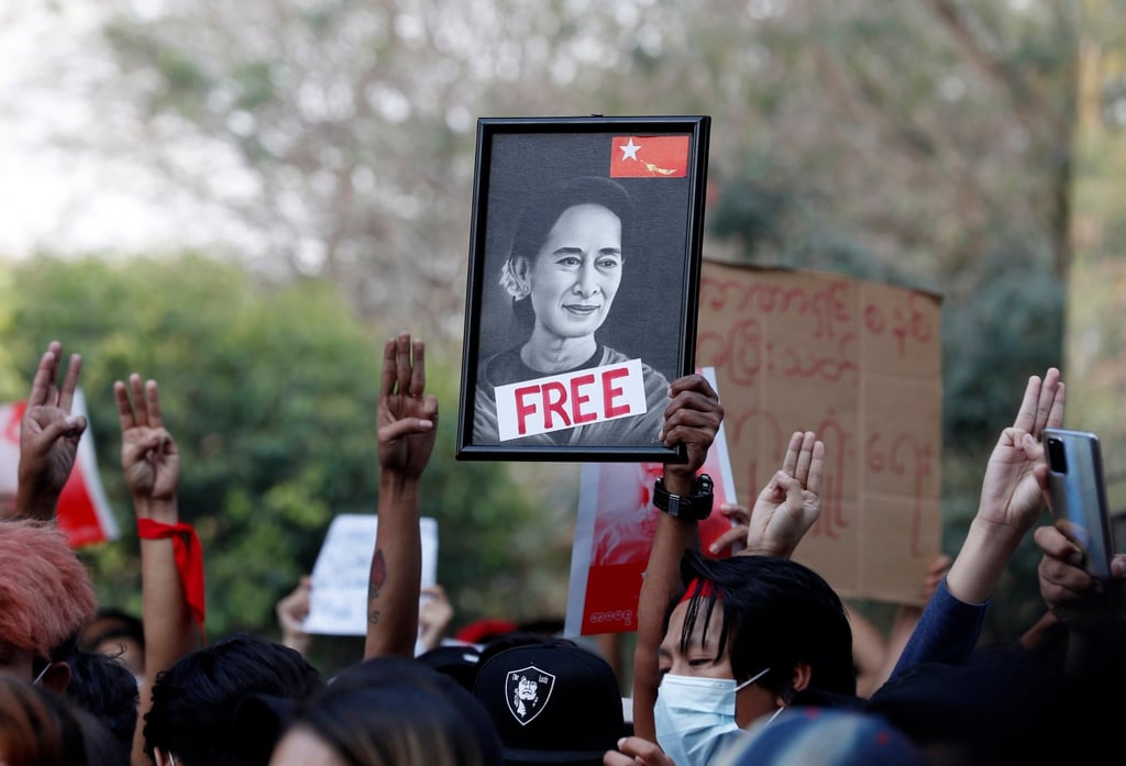 Protesters in Yangon, Myanmar, hold a portrait of Aung San Suu Kyi while flashing the three-finger salute, a symbol of resistance, during an anti-junta protest in February last year. Photo: EPA-EFE Protesters in Yangon, Myanmar, hold a portrait of Aung San Suu Kyi while flashing the three-finger salute, a symbol of resistance, during an anti-junta protest in February last year. Photo: EPA-EFE