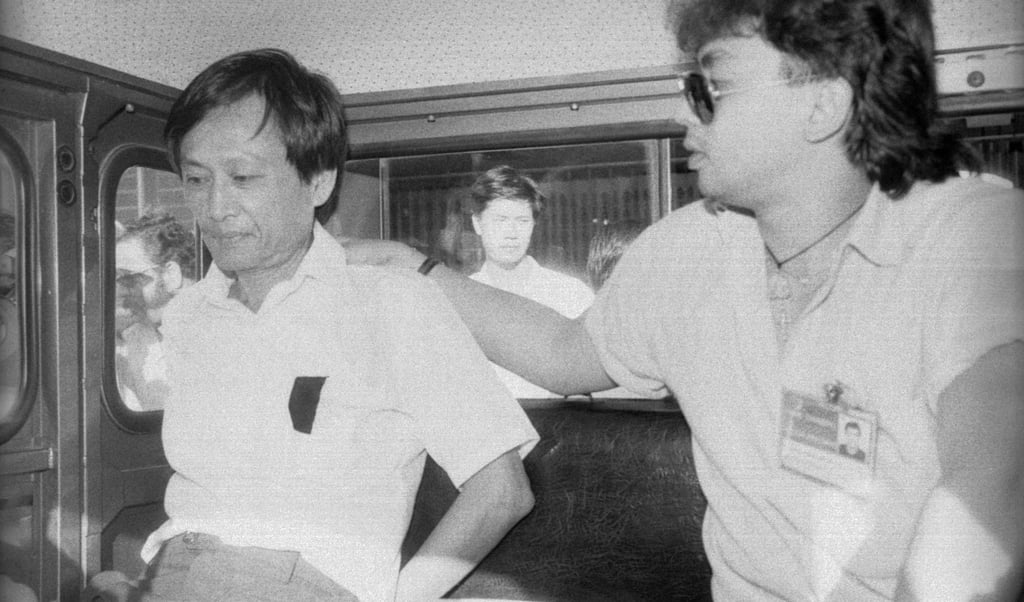 A Macau detective guards Law Kong on his way back to prison. His identity was discovered only when he applied for a Hong Kong identity card. Photo: Oliver Tsang