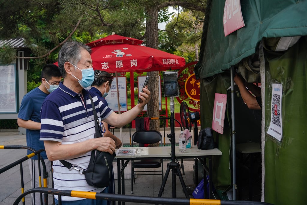 A man scans a health code before entering a vaccination site in Beijing. The Chinese capital made a policy U-turn on a vaccine mandate earlier this month. Photo: EPA-EFE