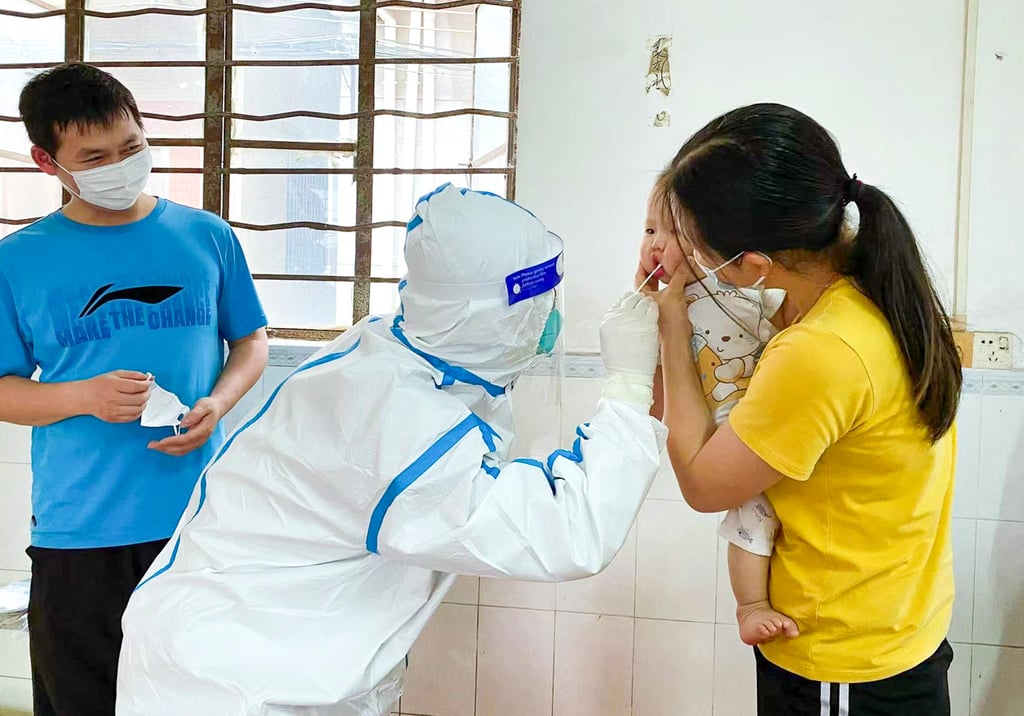 Vincent Wu collects a swab sample from a baby in a village in Guangdong province in April. Photo: Handout Vincent Wu collects a swab sample from a baby in a village in Guangdong province in April. Photo: Handout
