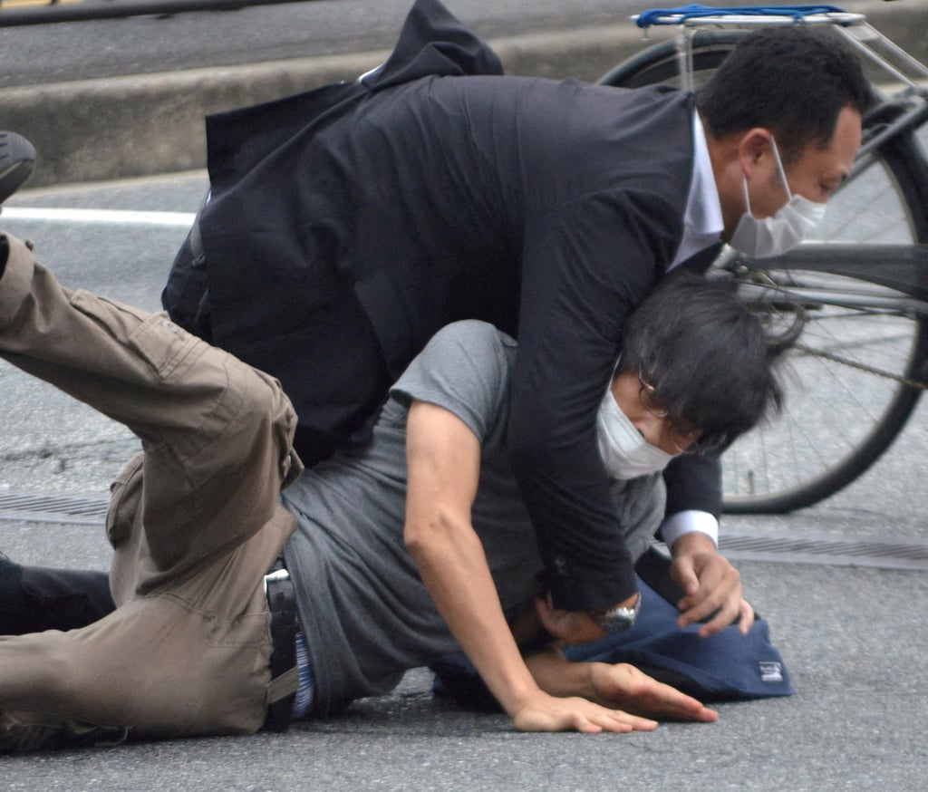 A police officer tackles a man identified as Tetsuya Yamagami after the shooting of Shinzo Abe on July 8. Photo: The Yomiuri Newspaper/via Reuters