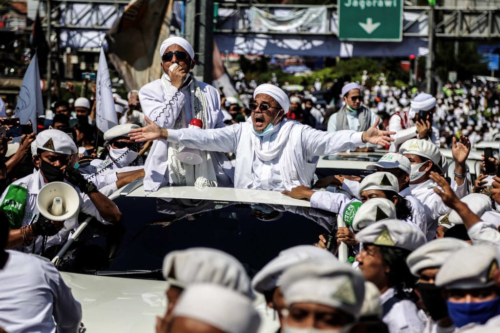 Rizieq Shihab, centre, gestures to supporters as he arrives to inaugurate a mosque in Bogor in November 2020. Photo: AFP Rizieq Shihab, centre, gestures to supporters as he arrives to inaugurate a mosque in Bogor in November 2020. Photo: AFP