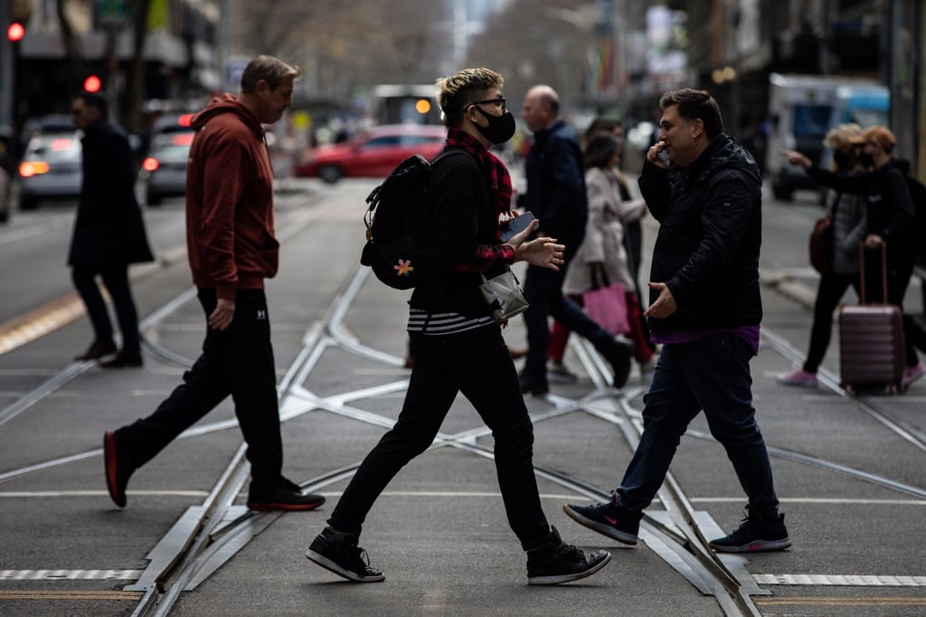 People cross the road in Melbourne on Tuesday. Australia is in the grip of an Omicron wave driven by highly transmissible subvariants. Photo: EPA-EFE