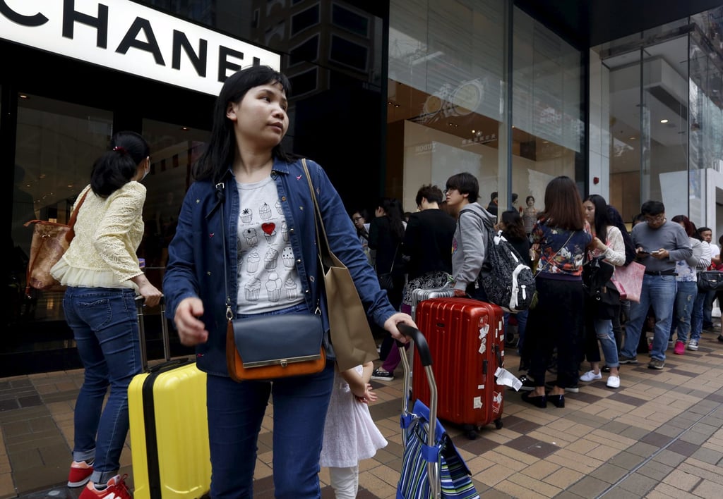 Mainland Chinese visitors wait outside a luxury store at a shopping district in Hong Kong in this file photo from March 19, 2015. Photo: Reuters Mainland Chinese visitors wait outside a luxury store at a shopping district in Hong Kong in this file photo from March 19, 2015. Photo: Reuters