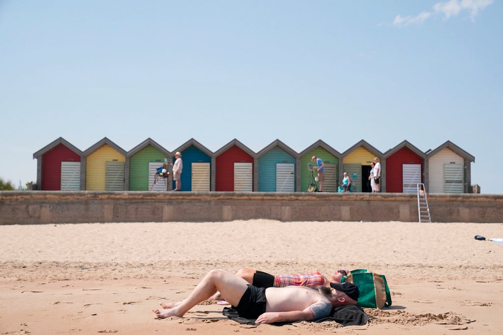 A couple on Blyth beach, Northumberland, on the northeast coast of England. Sunscreen is important to avoid skin damage. Photo: AP