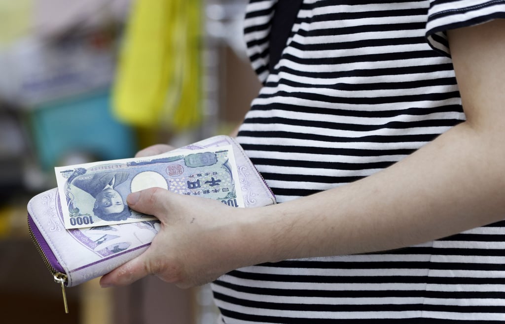 A customer holds a 1,000 yen banknote at a supermarket in Tokyo on June 27. Photo: Bloomberg