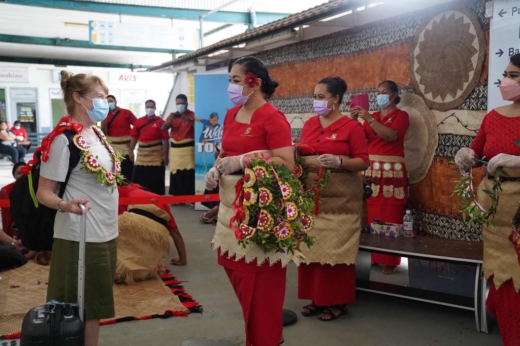 An international visitor (left) is welcomed with a kahoa (garland) by Tonga Ministry of Tourism staff. Photo: Linny Folau/Matangi Tonga/AFP An international visitor (left) is welcomed with a kahoa (garland) by Tonga Ministry of Tourism staff. Photo: Linny Folau/Matangi Tonga/AFP