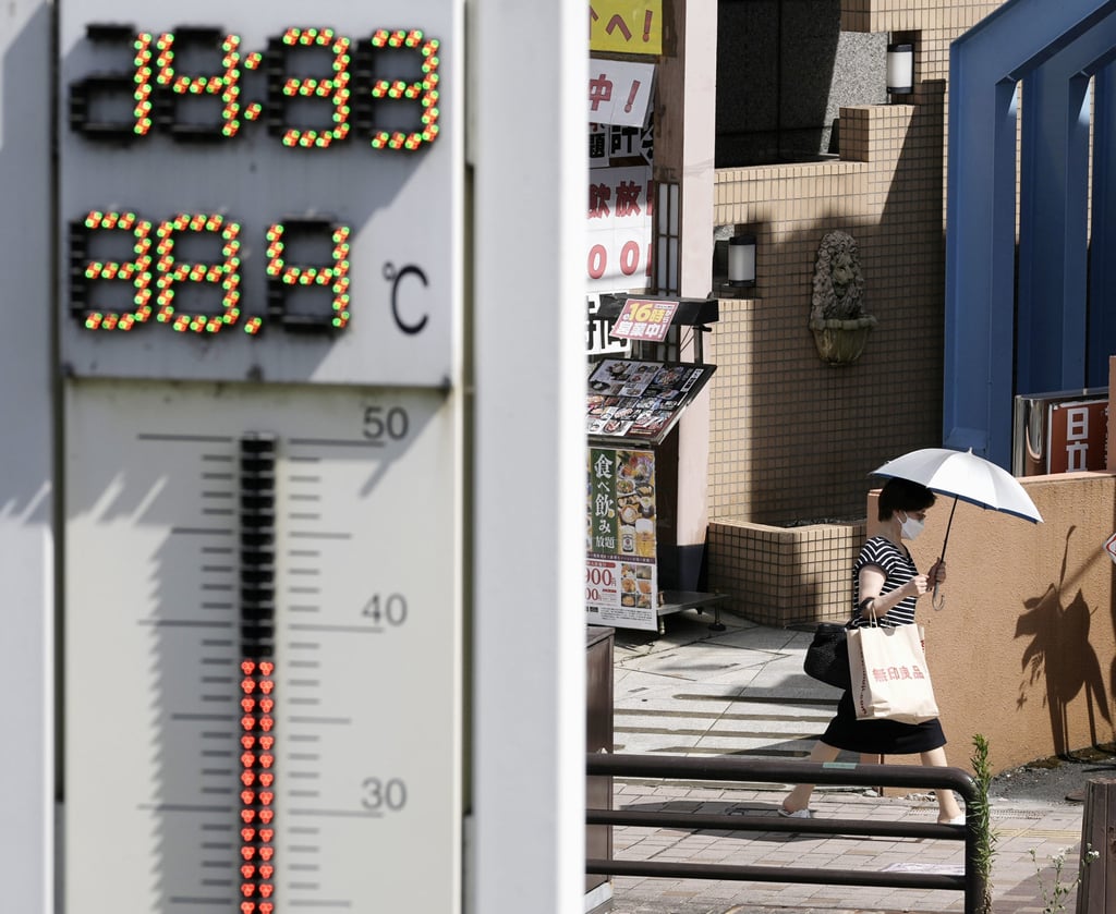 A woman walks with a parasol on a hot day in the Gifu prefecture city of Tajimi, central Japan, on August 2. Photo: Kyodo
