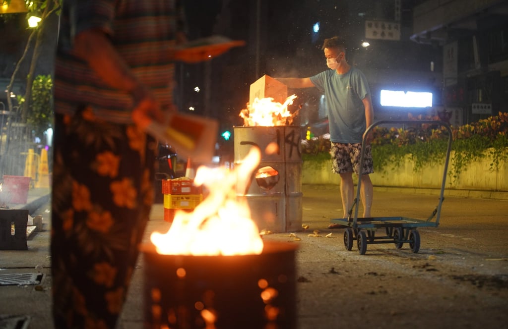 A man burns paper offerings during the Hungry Ghost Festival in Hong Kong’s Wan Chai neighbourhood. Photo: Winson Wong A man burns paper offerings during the Hungry Ghost Festival in Hong Kong’s Wan Chai neighbourhood. Photo: Winson Wong