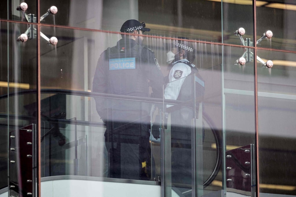 Police stand guard inside a terminal after a gunman opened fire at the airport in Canberra on August 14. Photo: AFP Police stand guard inside a terminal after a gunman opened fire at the airport in Canberra on August 14. Photo: AFP
