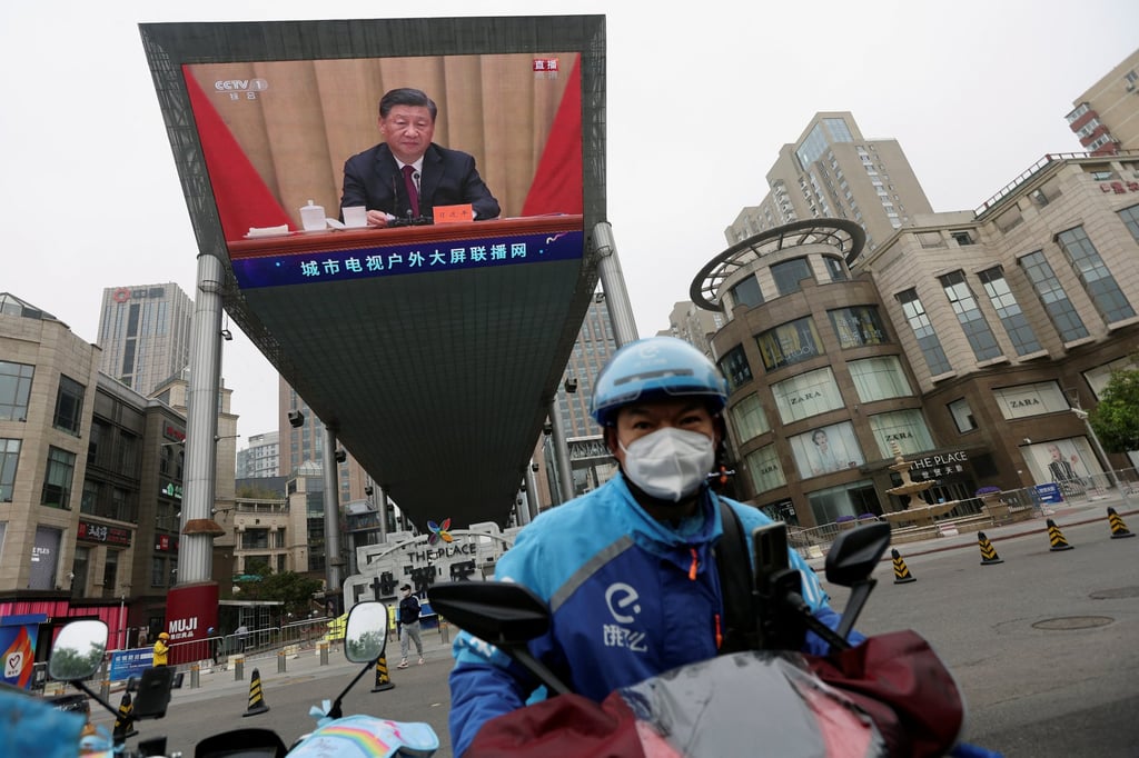 An Ele.me delivery worker rides near a giant screen showing Chinese President Xi Jinping. Photo: Reuters An Ele.me delivery worker rides near a giant screen showing Chinese President Xi Jinping. Photo: Reuters