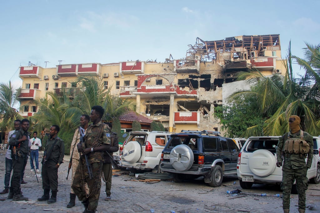 Security forces and others walk in front of the damaged Hayat Hotel in Mogadishu, Somalia on Sunday. Photo: AP