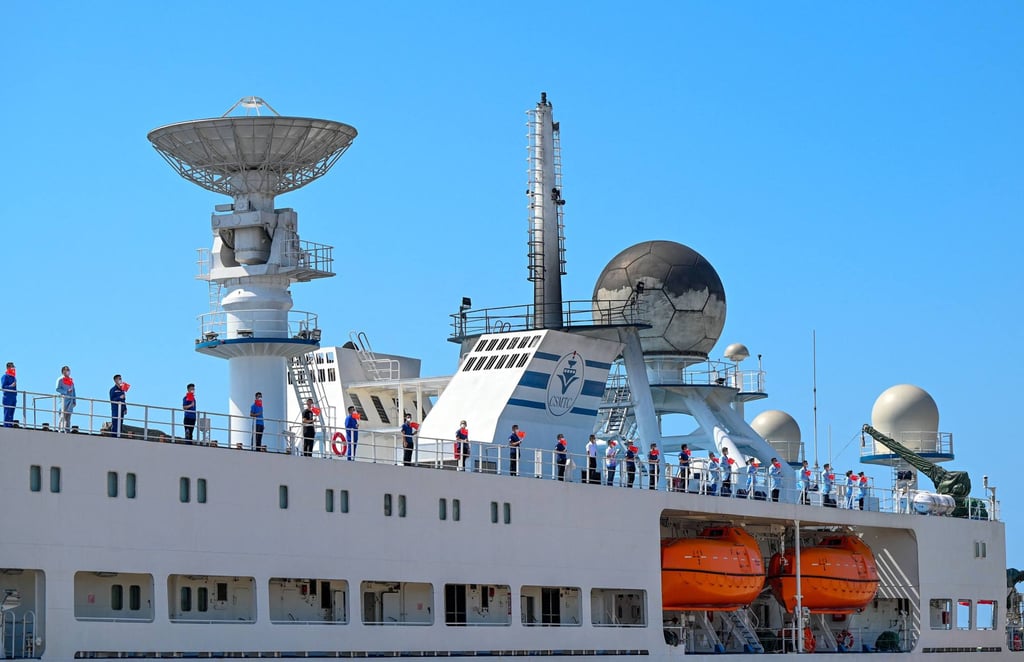 Crew members on board the Yuan Wang 5 hold Chinese flags as the vessel arrives at Hambantota port in Sri Lanka on August 16. Photo: AFP
