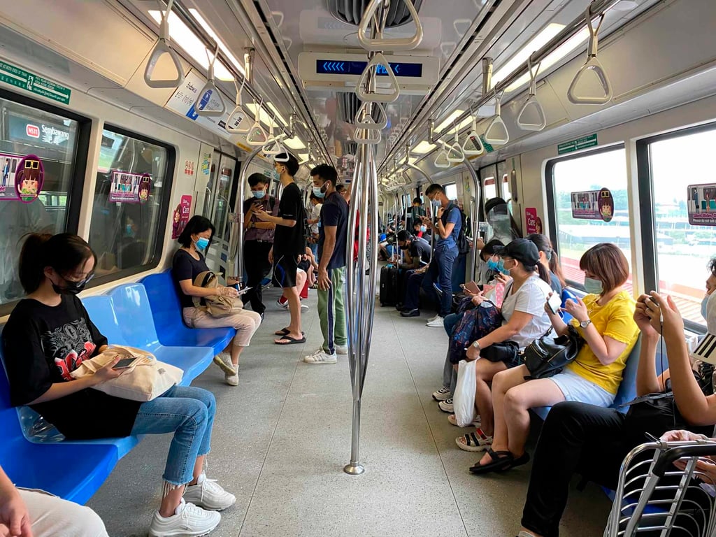 Commuters wear face masks on a subway in Singapore. Mask-wearing will still be compulsory on public transport. Photo: AP