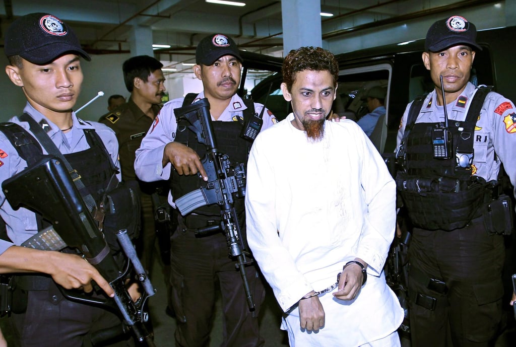 Indonesia’s Umar Patek (C) is escorted by police officers as he arrives at court in 2012. Photo: EPA Indonesia’s Umar Patek (C) is escorted by police officers as he arrives at court in 2012. Photo: EPA