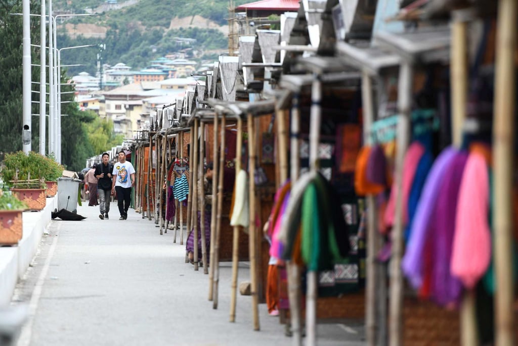 Tourists walk past stalls at a market in the Bhutanese capital Thimphu in 2018. Photo: AFP Tourists walk past stalls at a market in the Bhutanese capital Thimphu in 2018. Photo: AFP