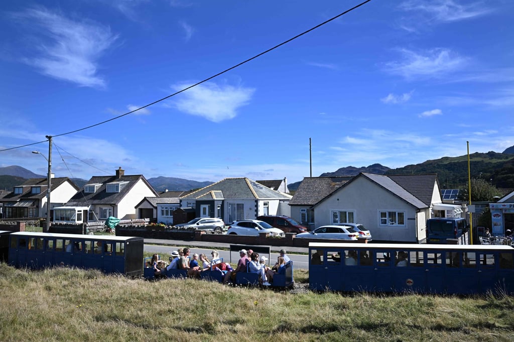 Visitors sit on the Fairbourne railway train during a sightseeing trip. Photo: AFP