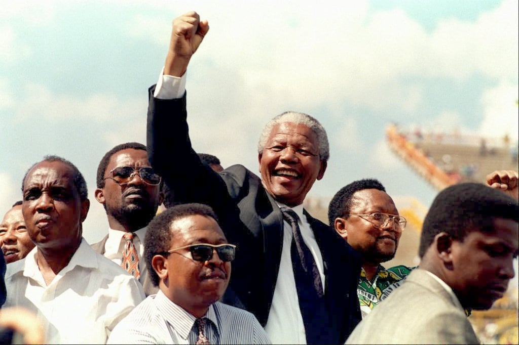 South African National Congress (ANC) President Nelson Mandela gives a clenched fist to supporters upon his arrival for his first election rally in 1994. South African National Congress (ANC) President Nelson Mandela gives a clenched fist to supporters upon his arrival for his first election rally in 1994.