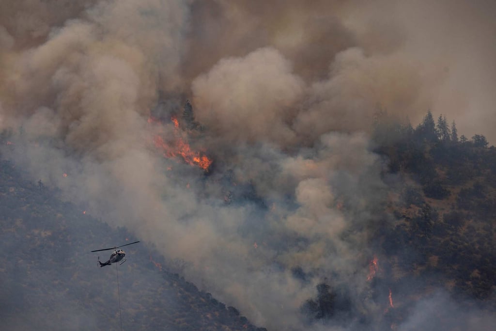 A firefighting helicopter flies over the Klamath National Forest near Yreka, California. Photo: AFP