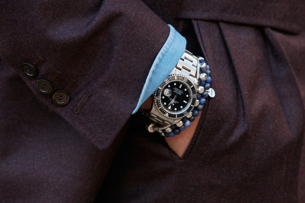 A man sports a steel Rolex Submariner watch and blue bracelets before Salvatore Ferragamo fashion show, Milan Fashion Week street style in January 2017, in Milan, Italy. Photo: Shutterstock