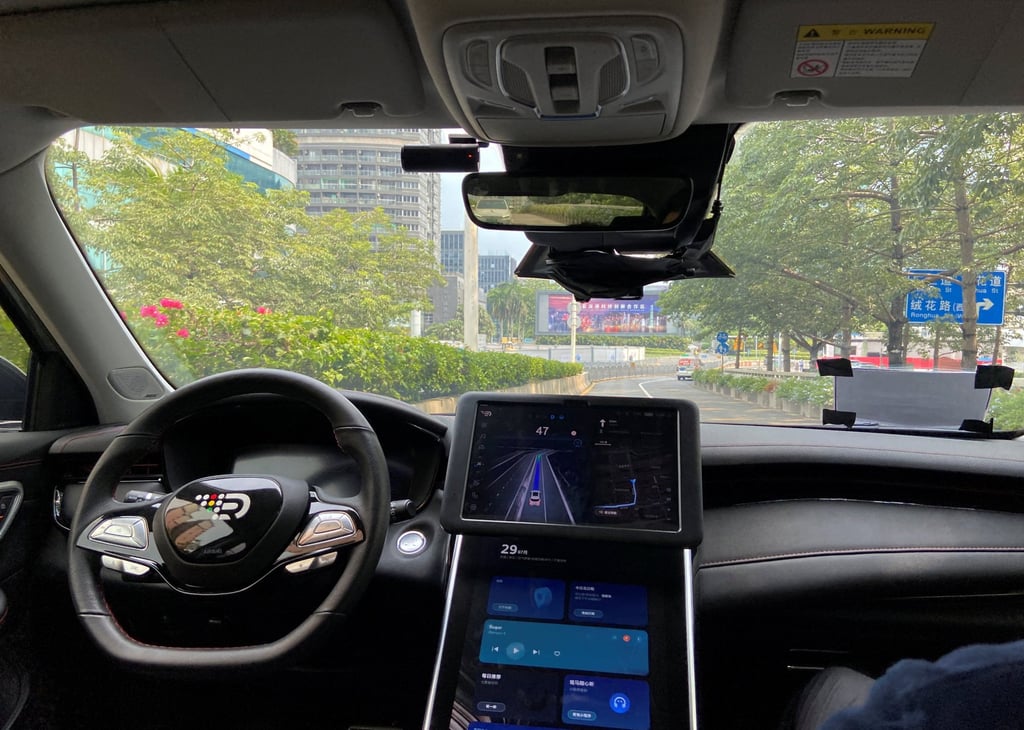 A safety driver sits in the passenger seat as a car with an autonomous driving system drives itself on a street in Shenzhen on July 29, 2022. Photo: Reuters