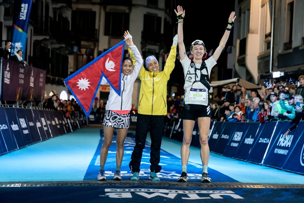 Sunmaya Budha [left] flies the flag of Nepal on the finish line of the CCC.