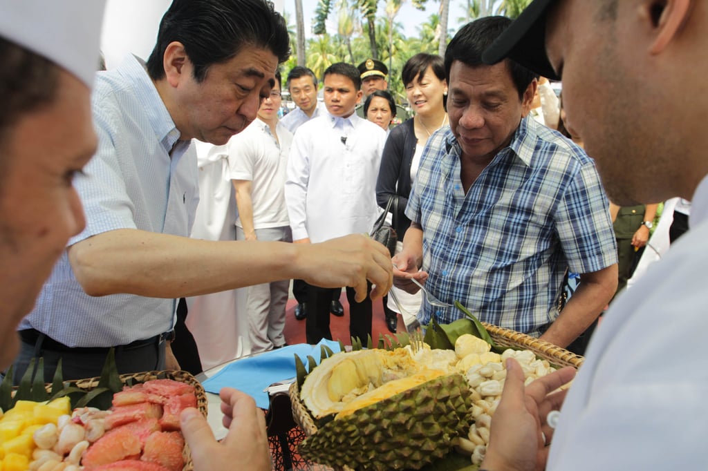 Japanese Prime Minister Shinzo Abe (left) eats durian with Philippine President Rodrigo Duterte during a visit to Davao City in 2017. Photo: AFP