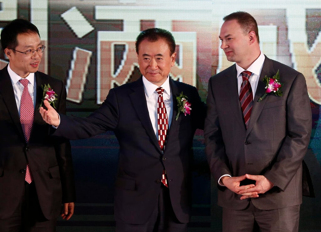 Wang Jianlin (centre), chairman of China’s Wanda Group, gestures to Thomas Tull (right), CEO of US film company Legendary, after signing a merger deal in Beijing, January 12, 2016. Photo: EPA