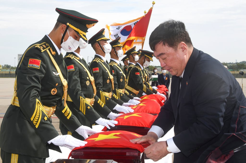 China’s ambassador to South Korea Xing Haiming covers the caskets containing the remains of Chinese soldiers killed in the Korean war, with the national flag. Photo: EPA-EFE China’s ambassador to South Korea Xing Haiming covers the caskets containing the remains of Chinese soldiers killed in the Korean war, with the national flag. Photo: EPA-EFE