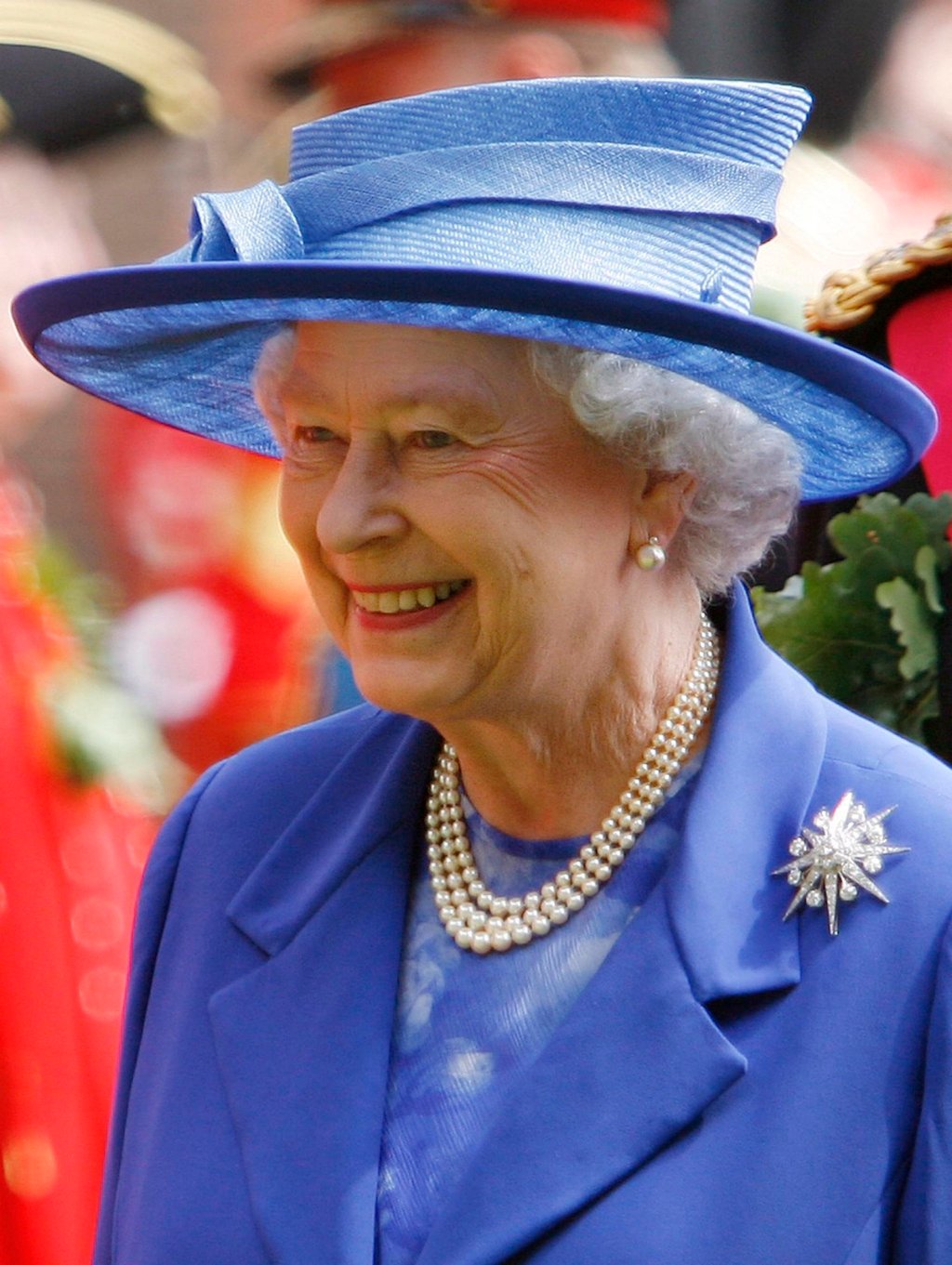 Britain’s Queen Elizabeth smiles wearing her iconic Three Strand Pearl Necklace as she as she inspects a rank of Chelsea Pensioners at the Royal Hospital Chelsea, in London, on Founder’s Day, in 2006. Photo: EPA