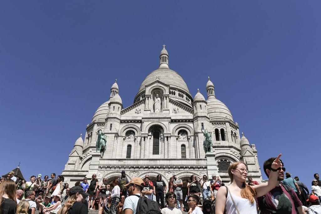 Tourists stand in front of the Sacre Coeur Basilica in Paris. The French capital has experienced a recent surge in visitors, especially from the US. Photo: AFP Tourists stand in front of the Sacre Coeur Basilica in Paris. The French capital has experienced a recent surge in visitors, especially from the US. Photo: AFP