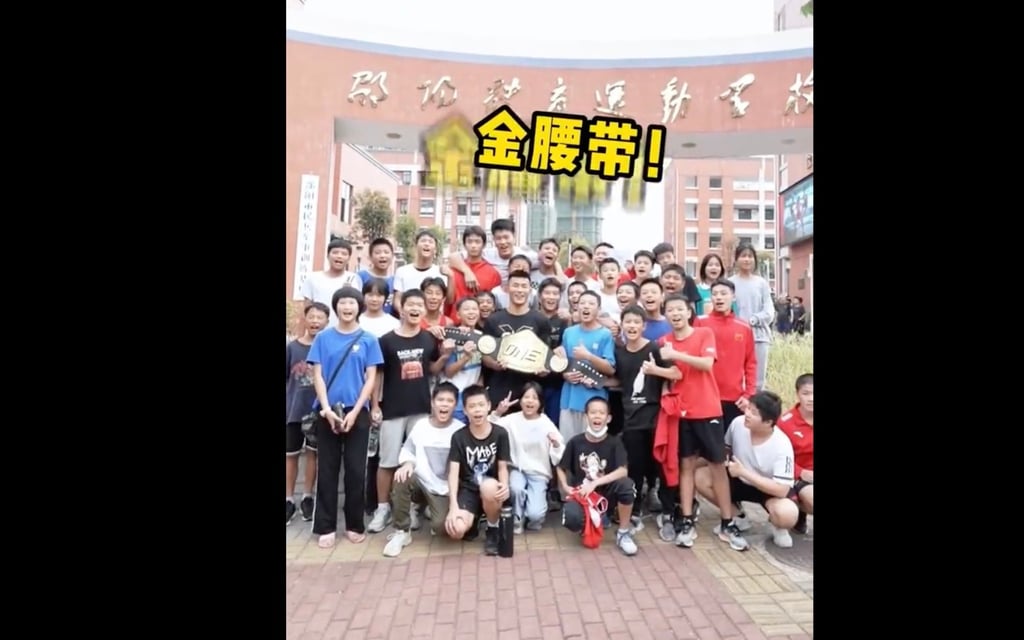 Tang Kai poses with students at his alma mater, Shaoyang Sports School.