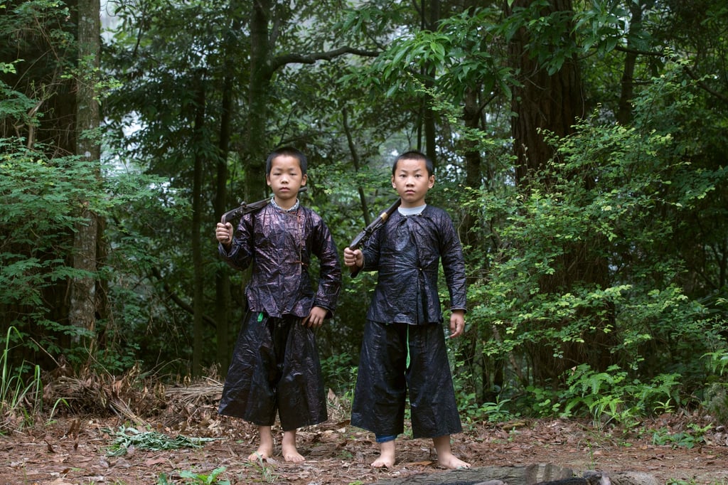 The Basha Miao are among the last hunter-gatherers of China; rifles and hunting knives are important accessories for men and boys. Photo: Cat Vinton / Thames & Hudson