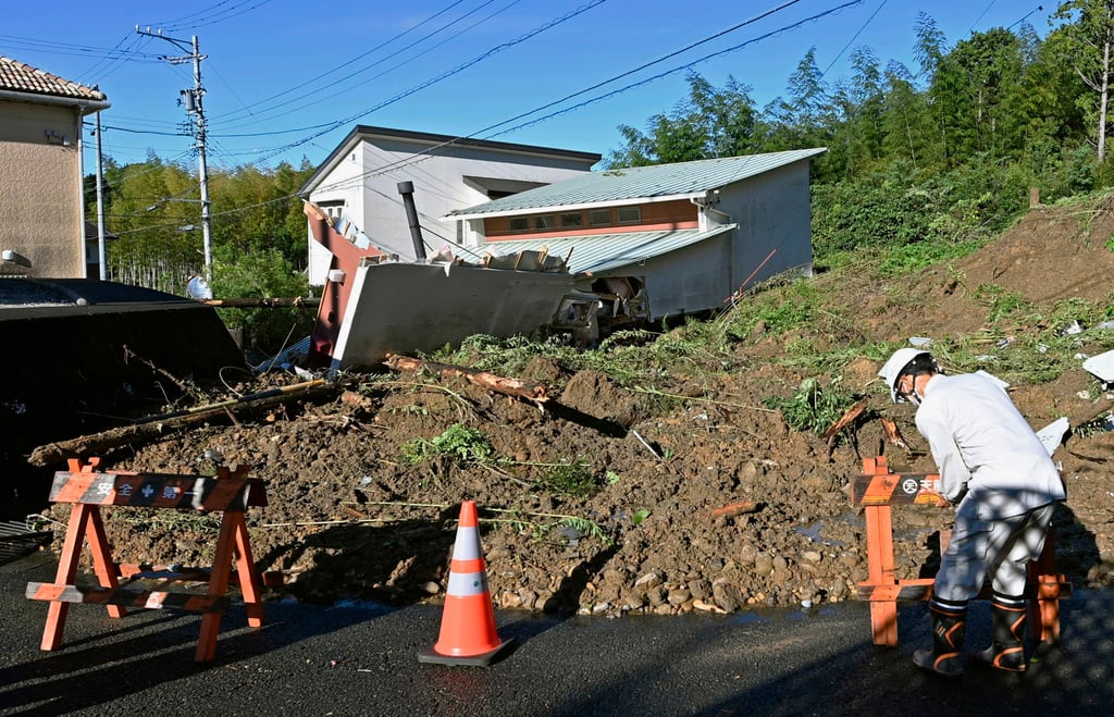 A worker places a barricade at the scene of a landslide in Hamamatsu, Japan’s Shizuoka Prefecture, on Saturday. Photo: Kyodo News via AP