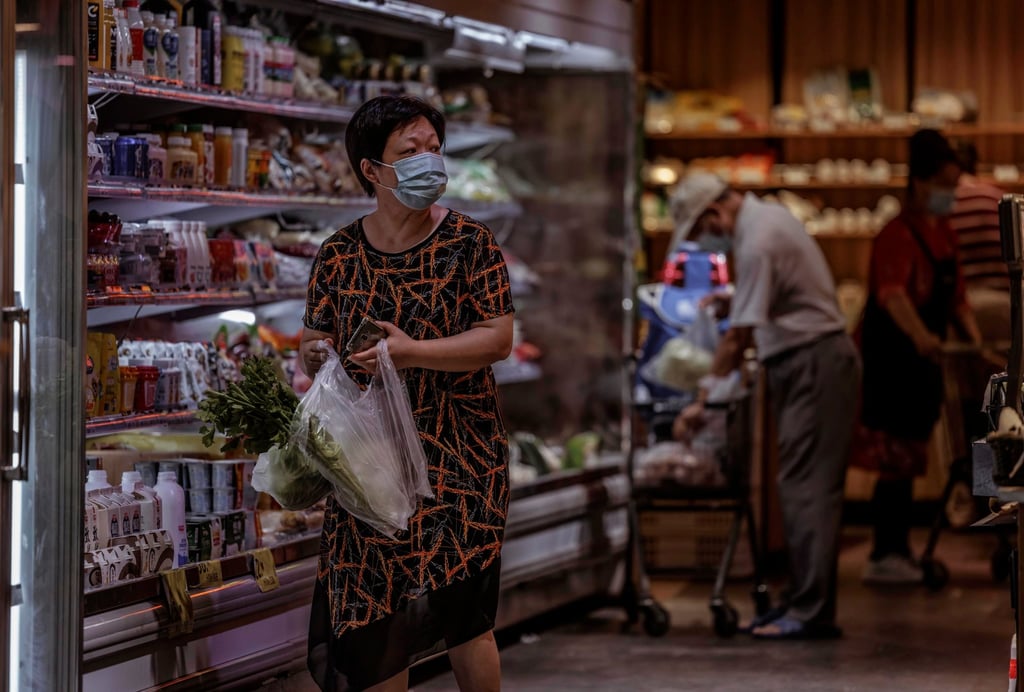 A woman buys food in a grocery shop in Shanghai on September 8, 2022. From January through August, retail sales in the city fell 12 per cent from a year earlier, according to the local statistics bureau. Photo: EPA-EFE