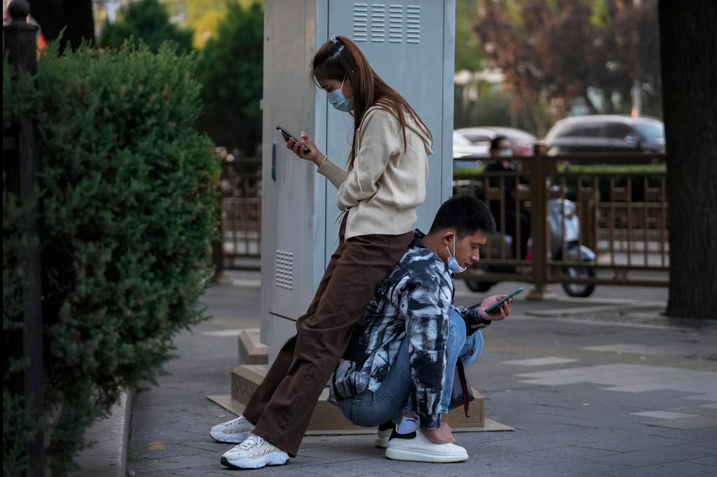 People browse their smartphones on a street in Beijing. Photo: AP Photo