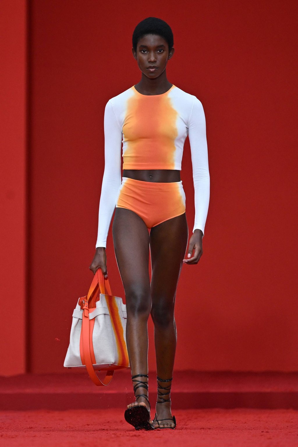 A model wears a white and orange ensemble for Ferragamo’s women’s and men’s spring/summer 2023 fashion collection presented on September 24, as part of the Fashion Week in Milan. Photo: AFP A model wears a white and orange ensemble for Ferragamo’s women’s and men’s spring/summer 2023 fashion collection presented on September 24, as part of the Fashion Week in Milan. Photo: AFP