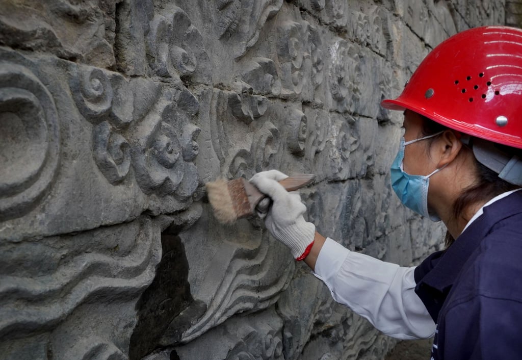 Archaeologists clean an ancient mural in central China. Photo: China