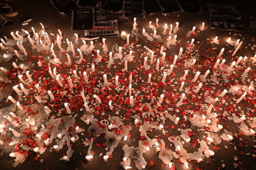 Candles, banners and flower petals are pictured during a candlelight vigil by Indonesian football supporters. Photo: AFP